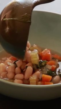  İtalyan fasulyesi ve ıspanak çorbası taze rendelenmiş parmesan peyniri ile nazikçe kaynıyor.