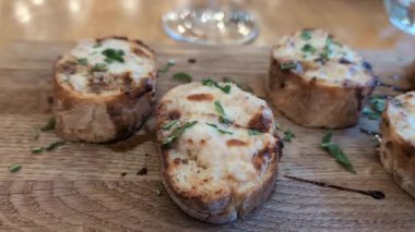 Ahşap bir tahtanın üzerine balzamik sirke serpiştirilmiş lezzetli parmesan bruschettalar.