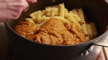 Kırmızı dolmalık biber soslu lezzetli ve kolay bir makarna tabağının yakın çekimi, rahatlatıcı bir akşam yemeği olarak sunuluyor.