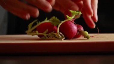 Tahta bir kesme tahtasının üzerinde taze turpları dilimleme videosu.