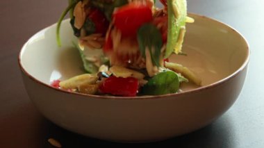 Lezzetli bir orzo salatasını taze malzemelerle karıştırma videosu.