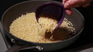 Tavada tavuklu makarna pişirilirken çekilmiş yakın çekim videosu.