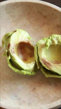  Kremalı avokado püresi yapmak için çatal kullanarak bir kâsede olgun avokadoyu ezmek.