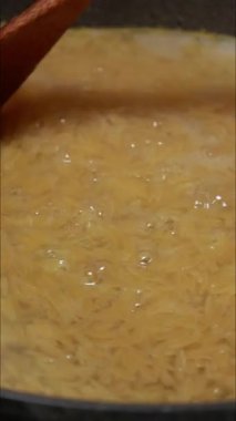 Tavada tavuklu makarna pişirilirken çekilmiş yakın çekim videosu.