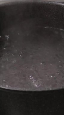 Makarnanın kaynayan bir tencerede pişirildiği yakın çekim video.