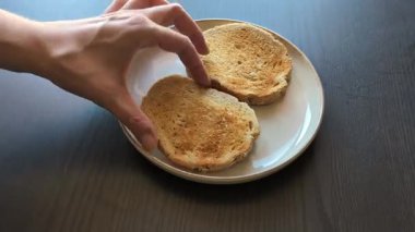 Üzerine kremalı avokado sosu serpiştirilmiş iki dilim ekmek yakın plan.