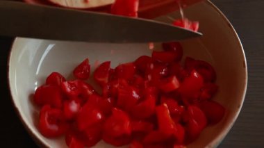 Çeri domatesler, kırmızı soğan, kapari ve maydanozdan yapılmış taze salsa sosu kasede servis edilir.