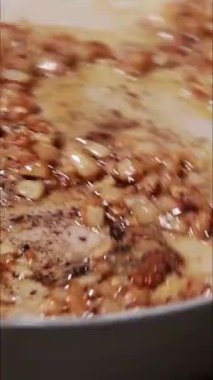 Tavada doğranmış soğanın pişirildiği dikey yakın çekim video.