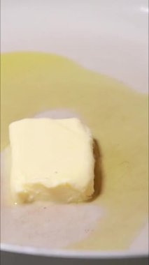 Tereyağının tavada yavaşça eridiği dikey yakın çekim videosu
