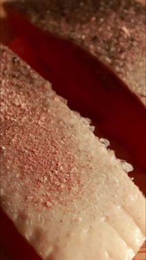 Tahta kesme tahtasında taze somon filetosu hazırlıyorum. Somon budanır, kurutulur, kurutulur ve terbiye edilir, pişirmeye hazırlanır.