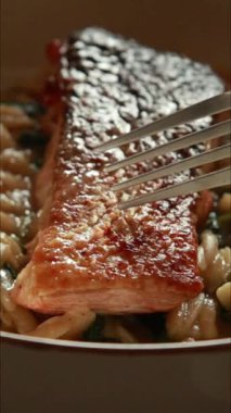 Lezzetli somon fileto tavada kızartılmış, kremalı orzo ve sotelenmiş ıspanakla servis ediliyor.