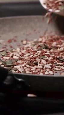 Tavada kızartılmış tohumların hazırlandığı dikey yakın çekim videosu