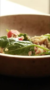  Protein ve sağlıklı yağlarla doldurulmuş kinoa salatası. İçinde avokado, nohut ve tohum gibi malzemeler var. Temiz, enerjik ve kasede servis edilen fitness dostu bir yemek.