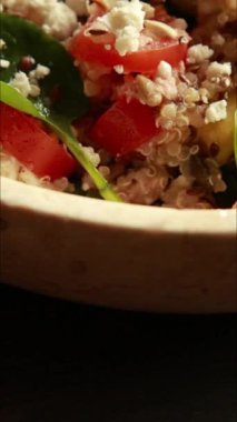  Protein ve sağlıklı yağlarla doldurulmuş kinoa salatası. İçinde avokado, nohut ve tohum gibi malzemeler var. Temiz, enerjik ve kasede servis edilen fitness dostu bir yemek.