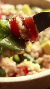  Protein ve sağlıklı yağlarla doldurulmuş kinoa salatası. İçinde avokado, nohut ve tohum gibi malzemeler var. Temiz, enerjik ve kasede servis edilen fitness dostu bir yemek.
