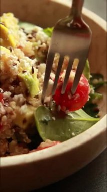  Protein ve sağlıklı yağlarla doldurulmuş kinoa salatası. İçinde avokado, nohut ve tohum gibi malzemeler var. Temiz, enerjik ve kasede servis edilen fitness dostu bir yemek.