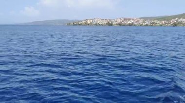Makedonya bölgesindeki Chalkidiki yarımadasında, Selanik 'in güneydoğusunda Yunanistan' da yer alan Nikiti köyünün güzel kıyı şeridine yakın bir manzara. Sahne, sakin mavi suyu gösteren bir tekneden çekiliyor.