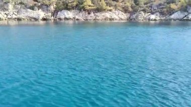 Makedonya bölgesindeki Chalkidiki yarımadasında, Selanik 'in güneydoğusunda Yunanistan' da yer alan Nikiti köyünün güzel kıyı şeridine yakın bir manzara. Sahne, sakin mavi suyu gösteren bir tekneden çekiliyor.