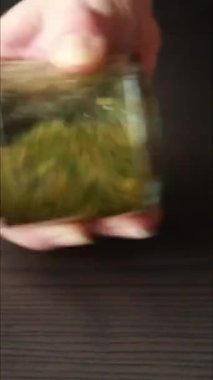 Yeşil taze otlarla dolu bir kavanozda lezzetli bir salata sosu hazırlama sürecini gösteren yakın çekim videosu.