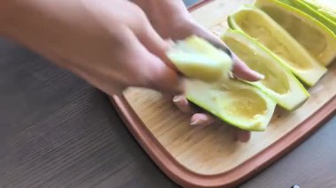  Kadının elleri dikkatle tahta kesme tahtasına kabak oyuyor. Tohumları çıkarıyor.