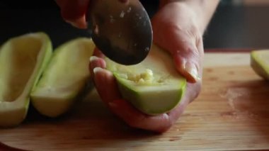  Kadının elleri dikkatle tahta kesme tahtasına kabak oyuyor. Tohumları çıkarıyor.