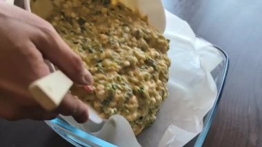 Karışımı kabuksuz peynirli kabuklu kiş yapmak için pişirme tepsisine dökülüyor.