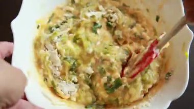 Kabuksuz bir kabuksuz peynirli kabuklu kiş hazırlamak için bir kaseye karıştırılan malzemelerin yakın plan çekimi.