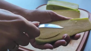  Kadının elleri dikkatle tahta kesme tahtasına kabak oyuyor. Tohumları çıkarıyor.