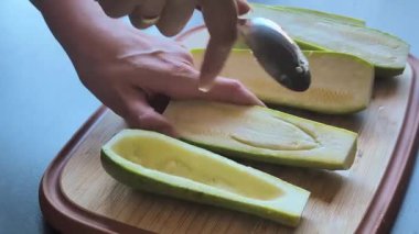  Kadının elleri dikkatle tahta kesme tahtasına kabak oyuyor. Tohumları çıkarıyor.