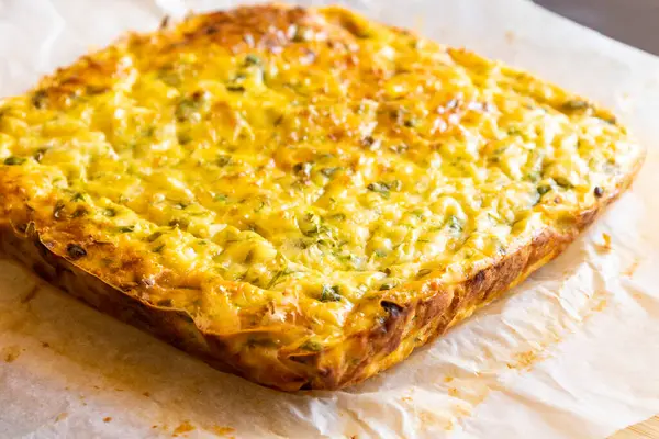 Lezzetli ve sağlıklı süzme peynirli kabaklı kiş. Bu altın fırınlanmış yemek bir kahvaltı ya da hafif bir öğle yemeği için mükemmel.