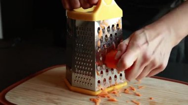 Kadın elleri evdeki taze havucu ızgaraya çeviriyor tahta kesme tahtasının üzerinde