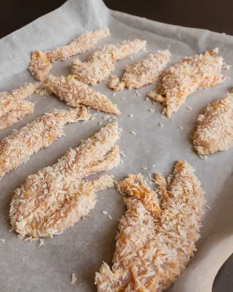 Hindistancevizi parçalarıyla kaplı çiğ tavuk filetolarının yakın plan fotoğrafı. Pişirmeye hazır. Taze, sağlıklı ve lezzetli tropikal yemek hazırlığı..