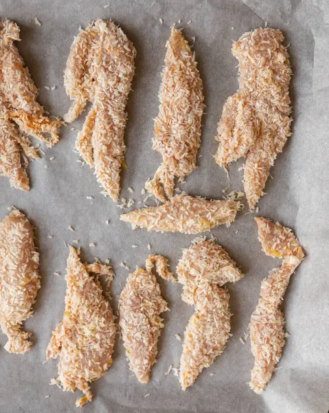 Hindistancevizi parçalarıyla kaplı çiğ tavuk filetolarının yakın plan fotoğrafı. Pişirmeye hazır. Taze, sağlıklı ve lezzetli tropikal yemek hazırlığı..