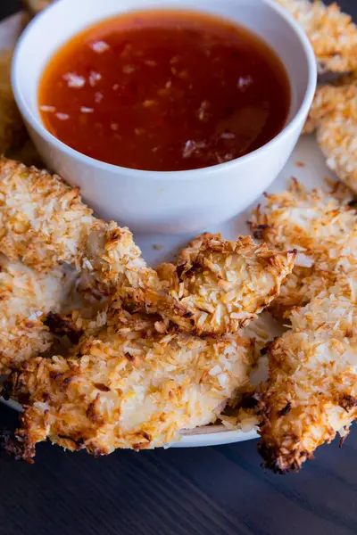  Hindistancevizi parçalarıyla kaplı tavuk filetoları, tatlı acı biber soslu bir tabağa konur. Tropikal lezzet yemeği, gevrek dokular, zengin bir tat. 