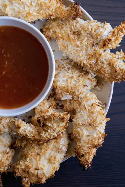  Hindistancevizi parçalarıyla kaplı tavuk filetoları, tatlı acı biber soslu bir tabağa konur. Tropikal lezzet yemeği, gevrek dokular, zengin bir tat. 