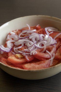 Taze doğranmış domateslerin ve kırmızı soğanın yakın plan fotoğrafı. Parlak kırmızı domates ve mor soğan halkaları.