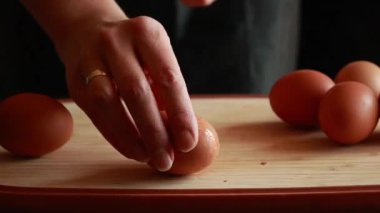 Kadın elleri haşlanmış yumurtayı kabuğundan çıkarıyor.