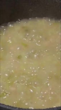 Taze pırasa, beyaz fasulye ve ıspanakla dolu bir tencerede sağlıklı bahar çorbası yapmak.