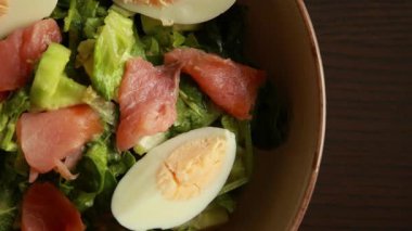 Sağlıklı yeşil salata, füme somon ve haşlanmış yumurta yakın plan.