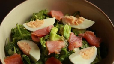 Sağlıklı yeşil salata, füme somon ve haşlanmış yumurta yakın plan.