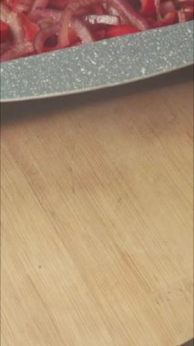 Tepside kırmızı soğan ve dolma biber kızartıp dikey videoyu kapat