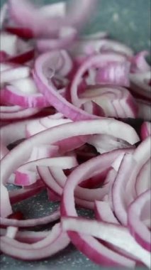 Dilimlenmiş kırmızı soğan parçaları tepside dikey videoyu kapat