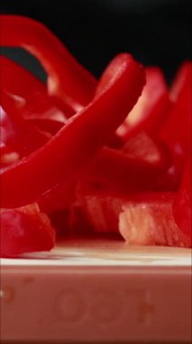 Tahta kesme tahtasındaki kırmızı dolma biberi dilimleyip temizlemek. Dikey videoyu kapat.