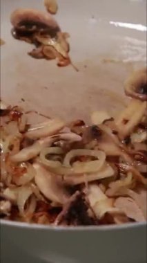 Bir tavada pişen mantar ve soğanları gösteren dikey stok videosu
