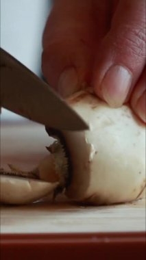 Tahta kesme tahtasıyla taze mantar kesen kadınların ellerini kapatın.