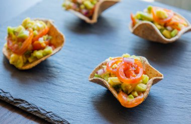 Guacamole ısırıkları taze bir parti aperatifi olarak servis edilir. Yaz etkinlikleri için mükemmel, sağlıklı atıştırma, ya da parmak yiyecek fikirleri için. Yemek blogcuları, yemek menüleri ve tarif içeriği için ideal
