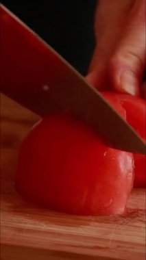 Kadın elleri tahta tahtada taze kırmızı domates doğruyor.