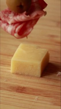 Salam, parmesan küpleri ve yeşil zeytinlerle yapılan lezzetli bir parti aperatifi şişinin dikey stok videosunu kapat.