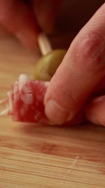 Salam, parmesan küpleri ve yeşil zeytinlerle yapılan lezzetli bir parti aperatifi şişinin dikey stok videosunu kapat.