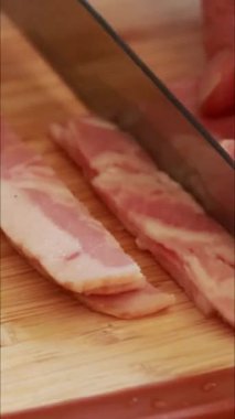 Kadın elleri ahşap tahtada pastırma dilimlerken dikey videoyu kapat